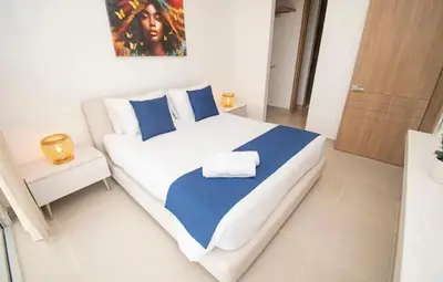 a bedroom with a large bed with blue and white sheets at Exclusivo Apartamento en Cartagena, Baia Kristal, Zona Kabo in Cartagena de Indias