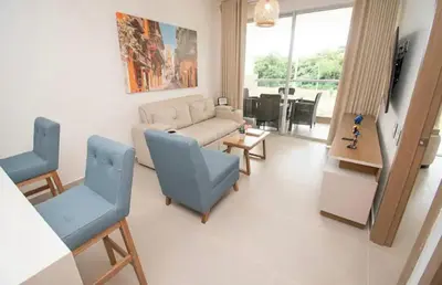 a living room with two blue chairs and a couch at Exclusivo Apartamento en Cartagena, Baia Kristal, Zona Kabo in Cartagena de Indias