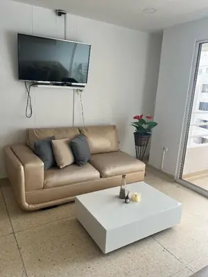 a living room with a couch and a tv on a wall at Apto en Edificio Centauro Ideal para tu estadia in Cartagena de Indias