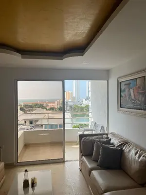 a living room with a couch and a large window at Apto en Edificio Centauro Ideal para tu estadia in Cartagena de Indias