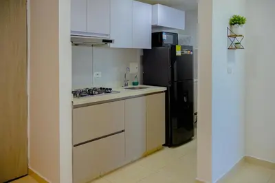 a kitchen with white cabinets and a black refrigerator at View 17, Modern, 5 min from Rafael Nuñez Airport in Cartagena de Indias