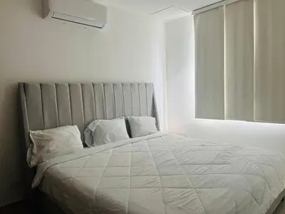 a white bed in a white room with a window at Luxury Apartment in Great Area! in Barranquilla