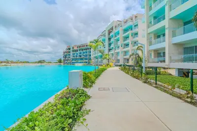 a pathway next to a large apartment building next to a body of water at kristal lagoon view apartement in Cartagena de Indias