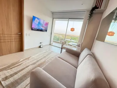 a living room with a couch and a tv at Suite Exclusiva Baia Kristal, Zona Kabo 3 in Cartagena de Indias