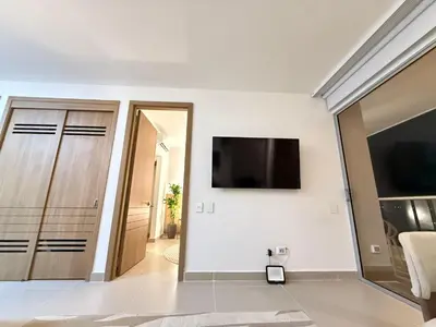 a white room with a flat screen tv on a wall at Suite Exclusiva Baia Kristal, Zona Kabo 3 in Cartagena de Indias