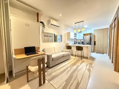 a living room with a couch and a table with a laptop at Suite Exclusiva Baia Kristal, Zona Kabo 3 in Cartagena de Indias