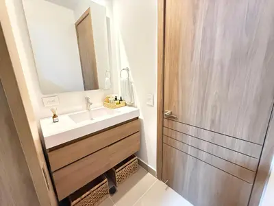 a bathroom with a sink and a mirror at Suite Exclusiva Baia Kristal, Zona Kabo 3 in Cartagena de Indias