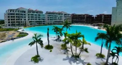 a large swimming pool with palm trees and buildings at Exclusivo Apartamento en Baia Kristal, Kabo 2 in Cartagena de Indias