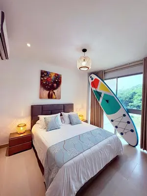 a bedroom with a bed with a surfboard on it at Exclusivo Apartamento en Baia Kristal, Kabo 2 in Cartagena de Indias