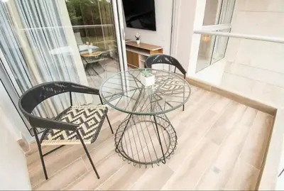 a glass table and two chairs on a balcony at Exclusivo Apartamento en Baia Kristal, Kabo 2 in Cartagena de Indias