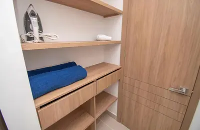 a closet with wooden shelves and a blue towel at Exclusivo Apartamento en Baia Kristal, Kabo 2 in Cartagena de Indias