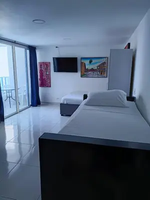 a bedroom with two beds and a tv on the wall at Estudio piso 9 APTO 909 in Cartagena de Indias
