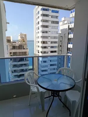 a table and chairs on a balcony with a view of the ocean at Estudio piso 9 APTO 909 in Cartagena de Indias