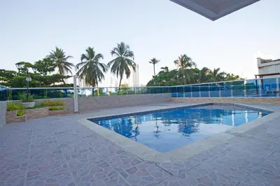 a swimming pool in a courtyard with palm trees at Riviera Mulata Loft - Apartamento con vista al mar in Cartagena de Indias