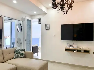 a living room with a couch and a tv on a wall at Amoblados Cartagena, El Laguito in Cartagena de Indias