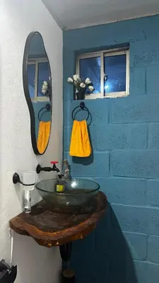 a bathroom with a green sink and a mirror at Cabaña la Industrial in Coveñas
