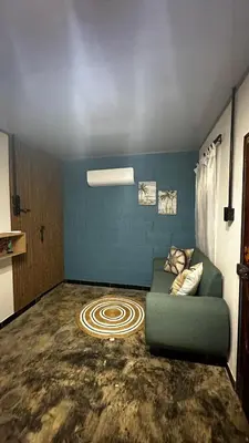a living room with a green couch and a carpet at Cabaña la Industrial in Coveñas