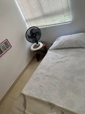 a bedroom with a bed and a fan on a table at Modern and renowned apartment in Cartagena in Cartagena de Indias