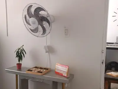a table with a fan on a white wall at Habitacion privada y central in Barranquilla
