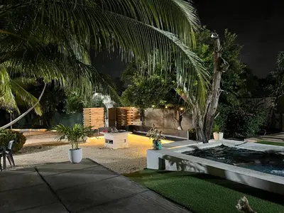 a garden with a palm tree and a motorcycle parked at House Las Palmas villa privada in Puerto Colombia