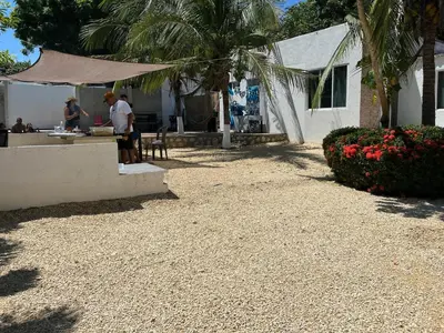 a man standing in a yard next to a house at House Las Palmas villa privada in Puerto Colombia
