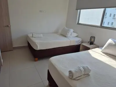 a hotel room with two beds and a window at 2H Encanto rentals at Sunno Beach in Cartagena de Indias