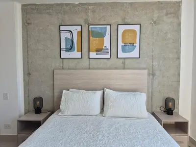 a bedroom with a bed with four pictures on the wall at 2H Encanto rentals at Sunno Beach in Cartagena de Indias