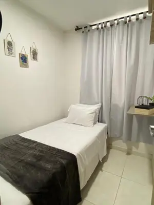 a bedroom with a bed with white sheets and a window at Premium stay in a central area with parking in Cartagena de Indias