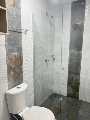 a bathroom with a toilet and a glass shower at Nora la bella in Barranquilla