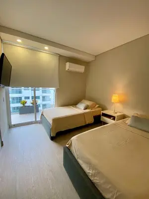a hotel room with two beds and a flat screen tv at Luxury Ocean View Aparment in Cartagena de Indias