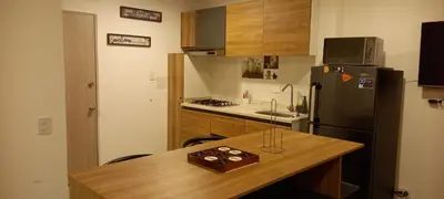 a kitchen with a wooden table and a refrigerator at Apartamento en Torices Piso 24 - Cartagena - Playa cerca al Mar in Cartagena de Indias