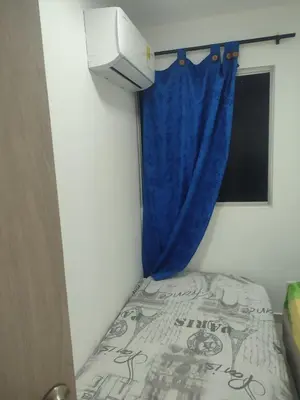 a small bedroom with a bed with a blue curtain at Sagitario hospedaje in Cartagena de Indias