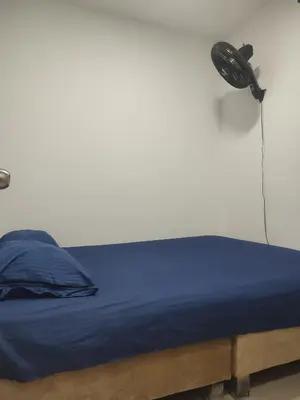 a bed with a blue blanket and a lamp at Sagitario hospedaje in Cartagena de Indias