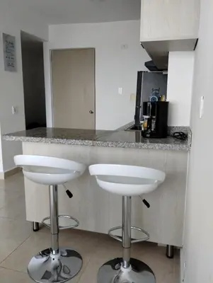 a kitchen with two white bar stools at a counter at New Apartment Frente al Mar, Cerca Getsemani in Cartagena de Indias