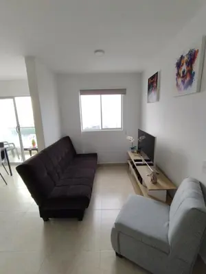 a living room with a couch and a television at New Apartment Frente al Mar, Cerca Getsemani in Cartagena de Indias