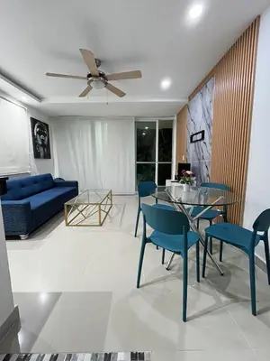 a living room with a blue couch and a table and chairs at Lindo & Cómodo Apartamento en La boquilla in Cartagena de Indias