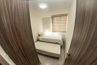 a small room with two beds and a window at Apartamento cerca al Mar y a el Centro Histórico in Cartagena de Indias