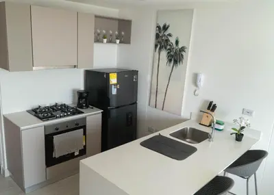 a kitchen with a black refrigerator and a stove at Loft Privado , Sunset y armonia in Santa Marta