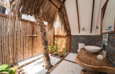 a bathroom with a sink and a tree in it at Eco Hotel Islabela Deluxe in Isla Grande