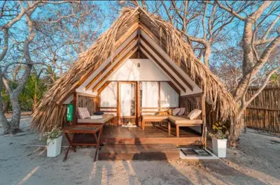 a small hut with a thatched roof in a field at Eco Hotel Islabela Deluxe in Isla Grande