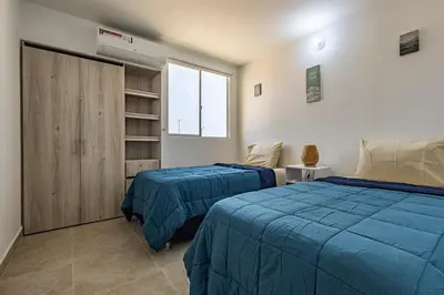 a bedroom with two beds and a closet at MarNilo House Serena del Mar Cartagena in Cartagena de Indias