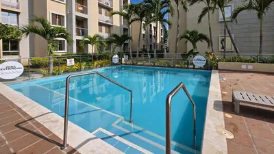 a large blue swimming pool in a building with palm trees at MarNilo House Serena del Mar Cartagena in Cartagena de Indias