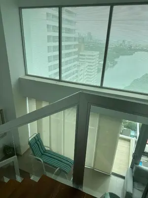 a blue chair sitting in a room with windows at Espectacular apartamento vista al centro y al Mar in Cartagena de Indias