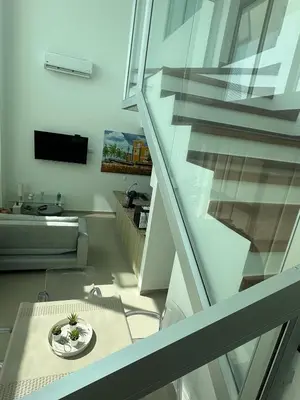 a living room with a staircase with a table at Espectacular apartamento vista al centro y al Mar in Cartagena de Indias