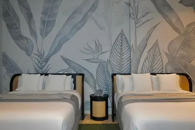 two beds in a room with a wall mural at Casa De La Imprenta in Cartagena de Indias