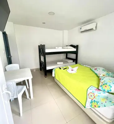 a small bedroom with a bed and a table at Hotel Y Restaurante La Quinta in Cartagena de Indias