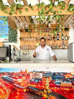 a man standing behind a counter in a city at Hotel Y Restaurante La Quinta in Cartagena de Indias