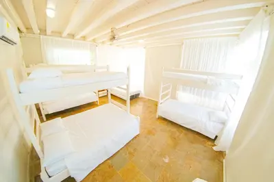 a room with three bunk beds and a couch at Quinta del Mar Tintipán in Isla Mucura