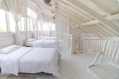 three beds in a room with white walls and windows at Quinta del Mar Tintipán in Isla Mucura