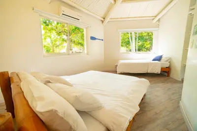 a bedroom with two beds and two windows at Quinta del Mar El Paraiso in Tolú